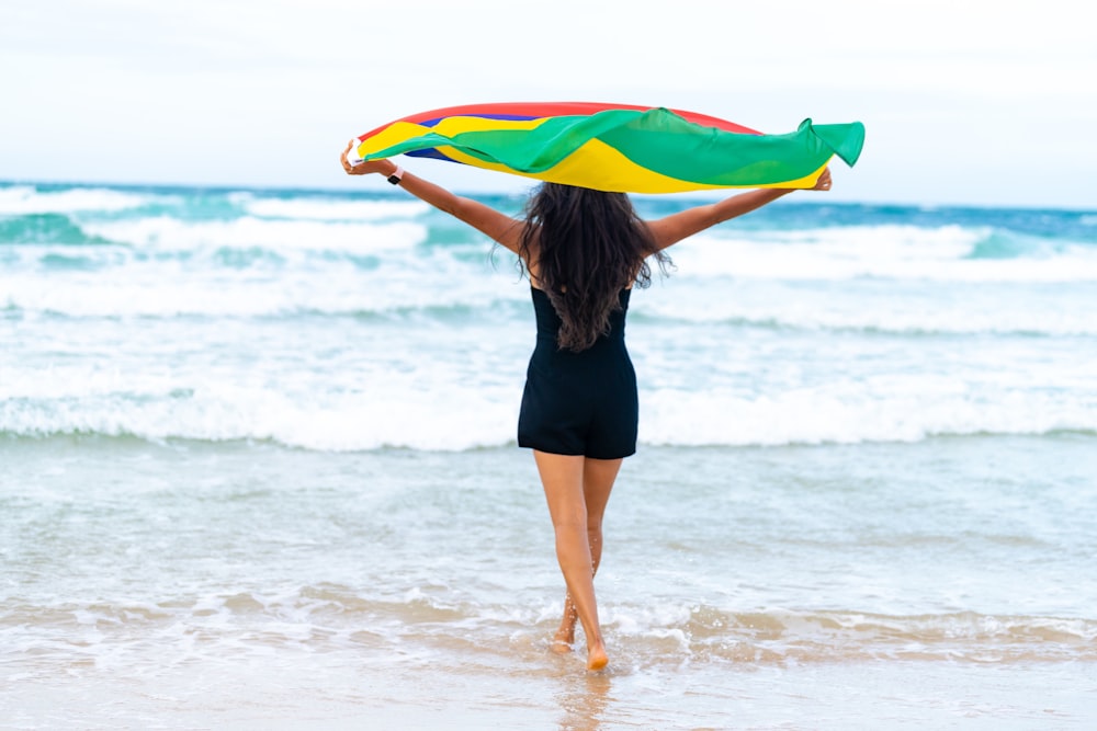 a woman holding a kite on the beach