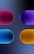 Four pill-shaped objects, each with a distinct gradient and color, are organized with two on the top and two on the bottom against a dark, gradient background. The shapes are glossy and three-dimensional, creating a soothing and futuristic aesthetic.