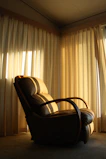 Arched back fabric accent chair in a sunlit corner with a cozy reading nook vibe.