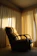 A beautifully restored vintage chair with plush cushions in a sunlit cozy corner.
