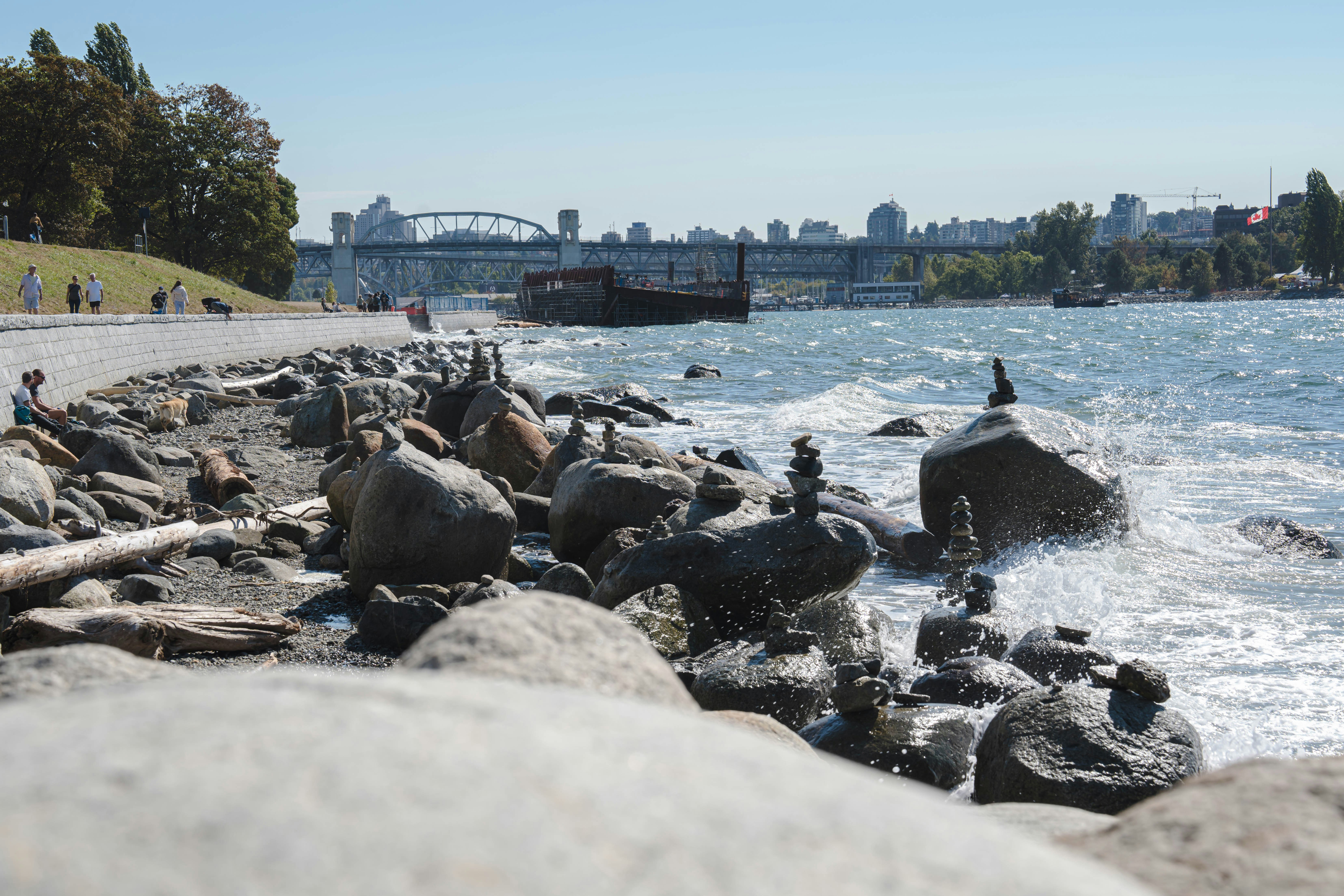 a group of people on rocks by a body of water