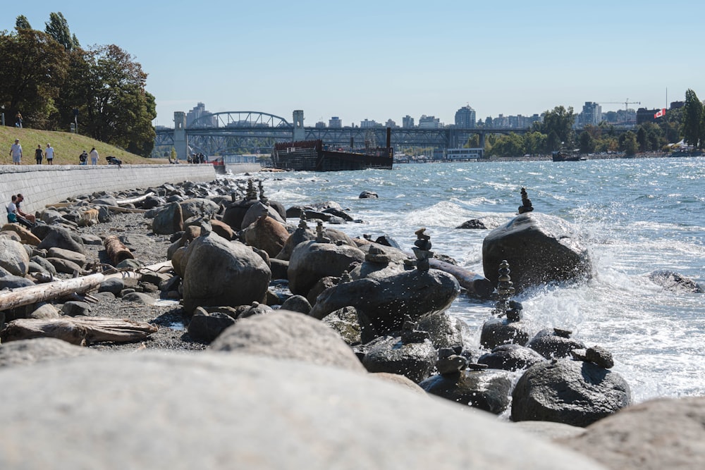 a group of people on rocks by a body of water