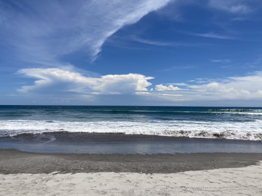 a beach with waves and blue sky