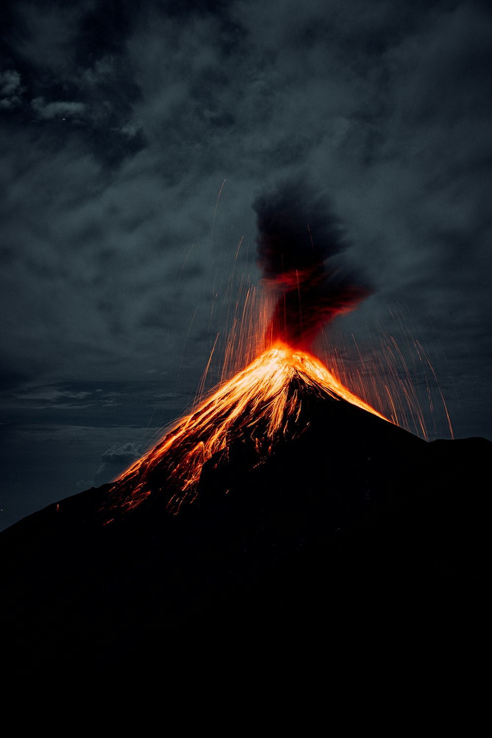 a silhouette of a person with a fire in the background