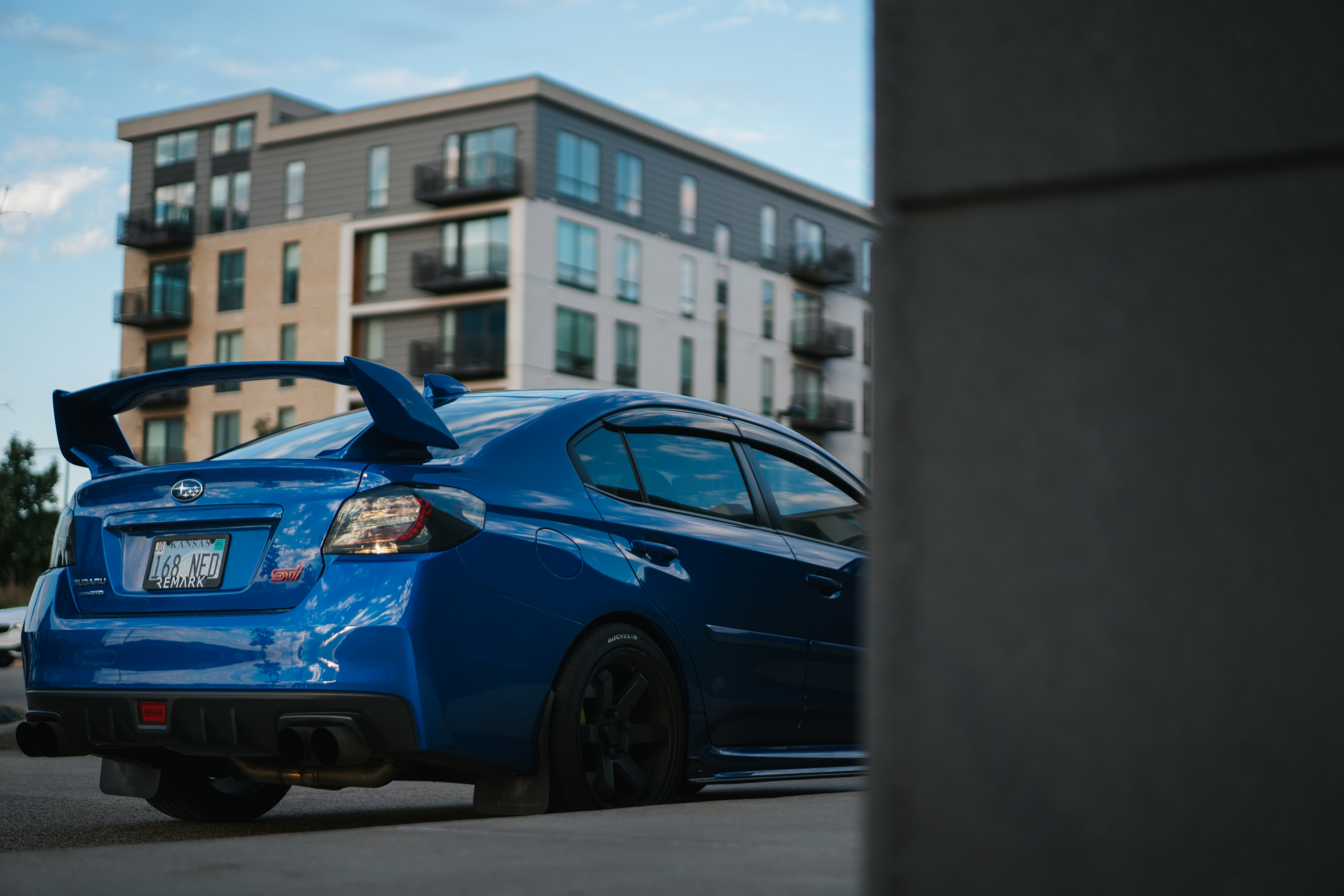 a blue car parked in front of a building