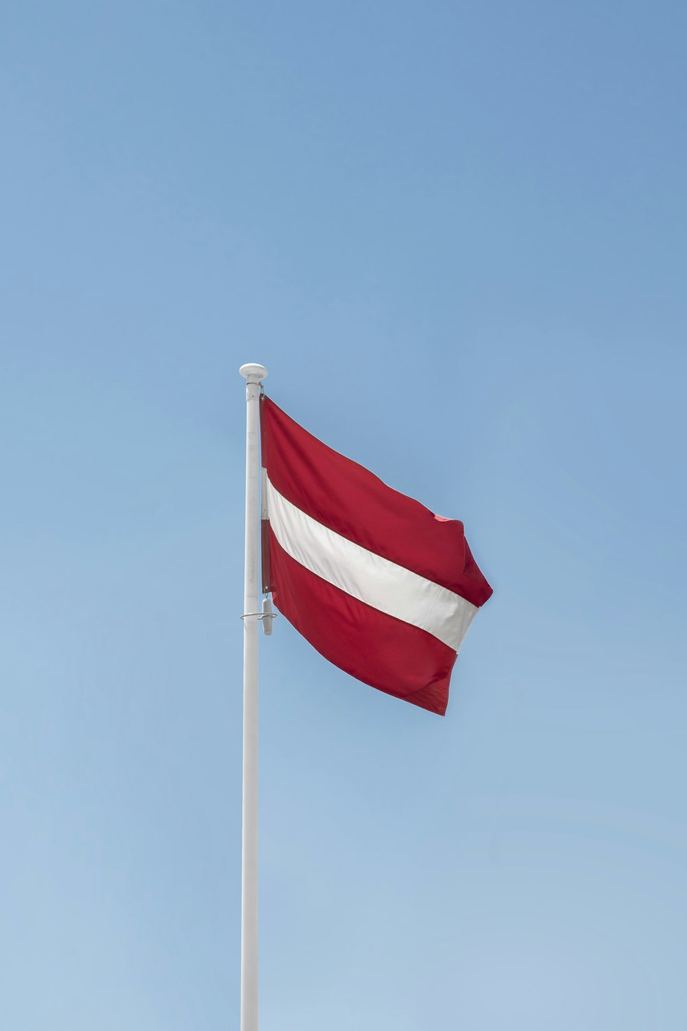 a red and white flag on a flagpole