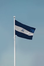 a blue and white flag on a flagpole