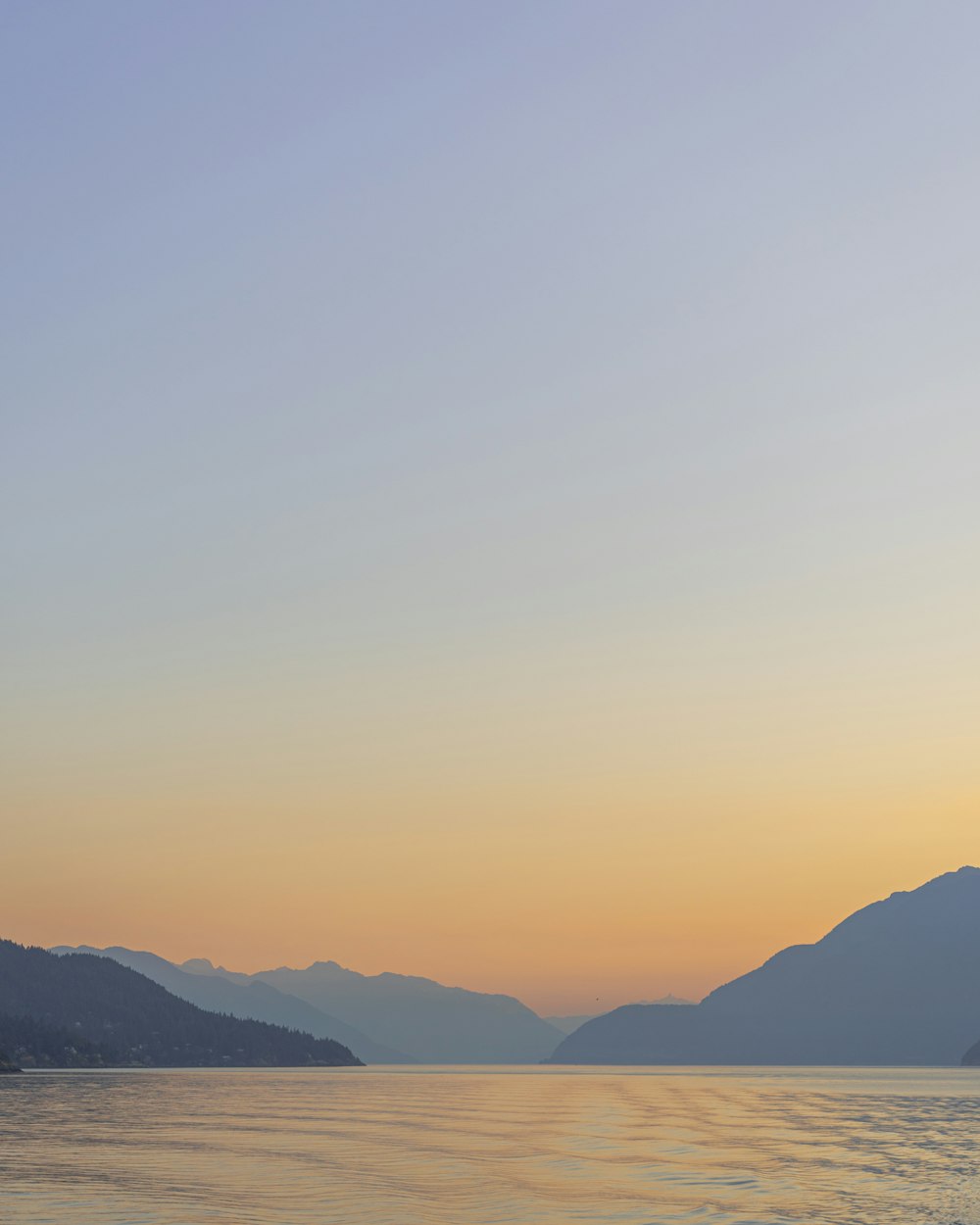 a body of water with mountains in the background