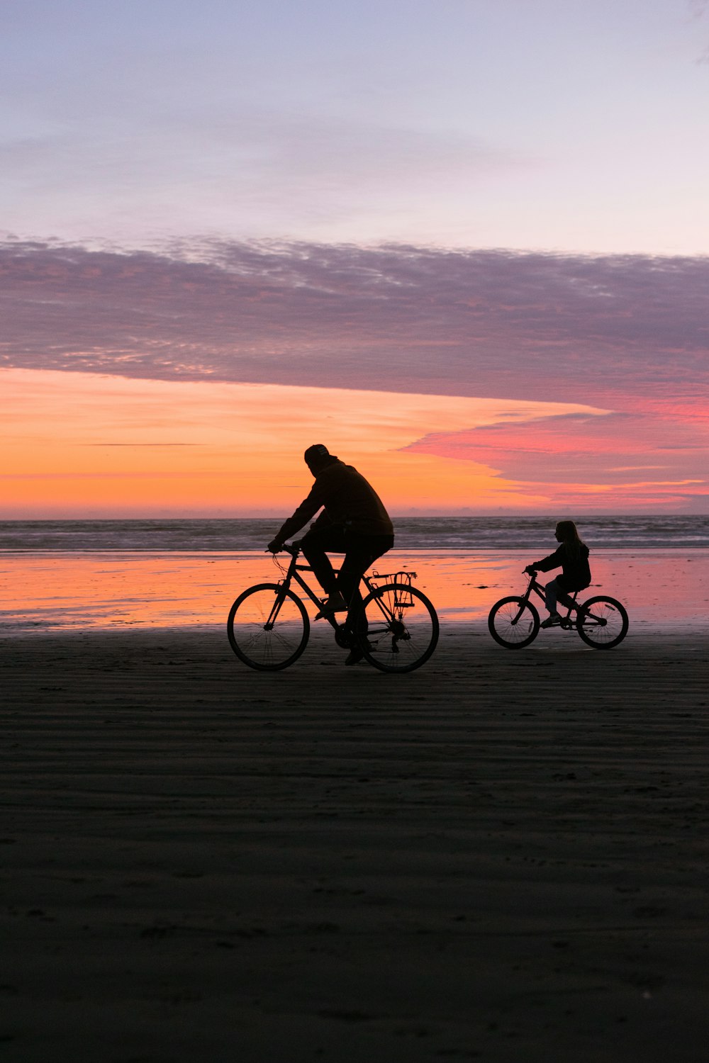 a group of people riding bikes on a beach