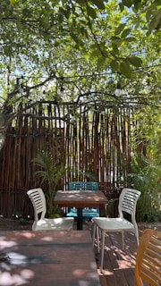 An outdoor garden seating area featuring comfortable chairs and a wooden table.