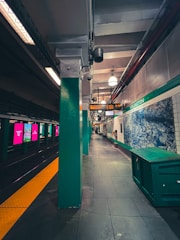 a train station with a green wall
