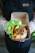 Happy customer holding a transparent microwavable deli container filled with fresh food.