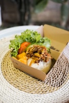 A steaming kottu box served in a rustic container, showcasing its rich textures.