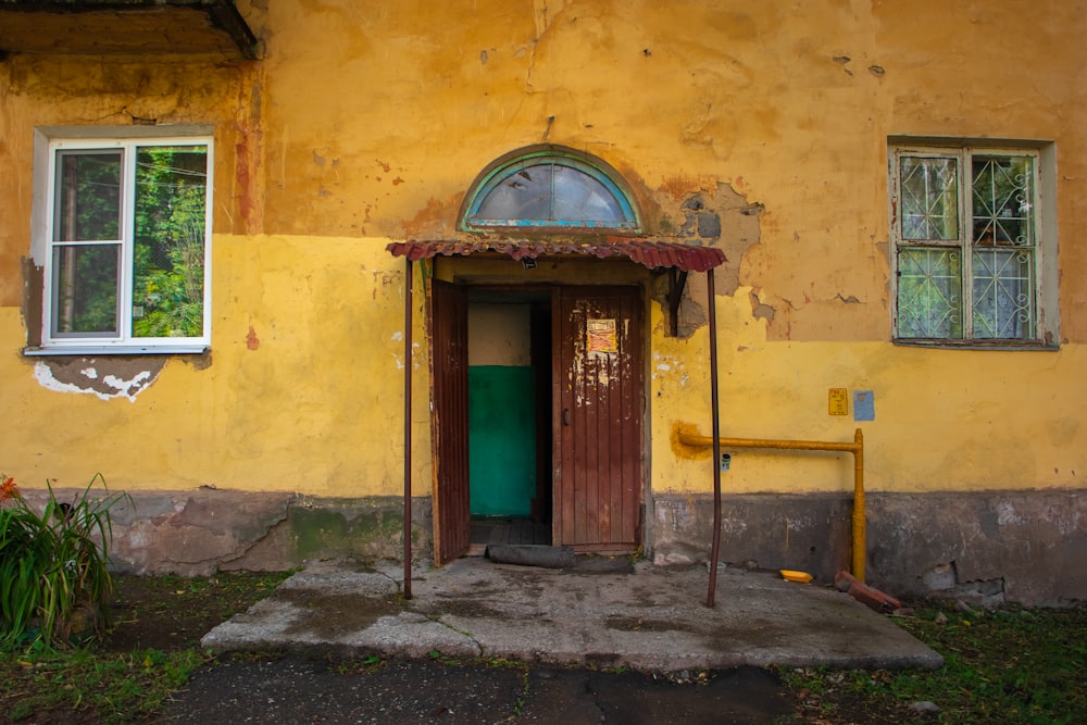 a yellow building with a door and windows