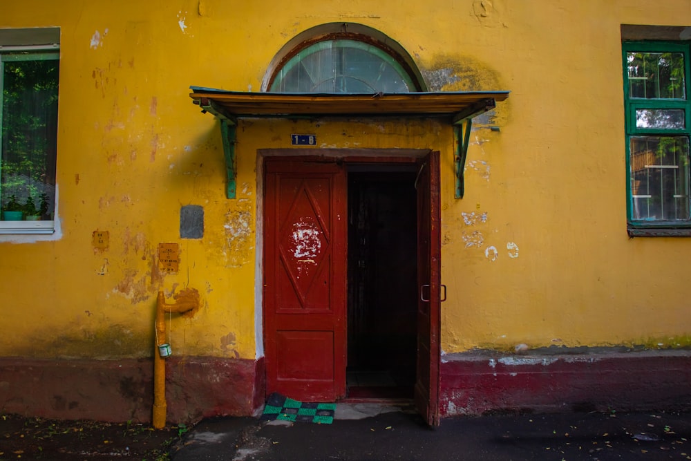 a yellow building with a red door