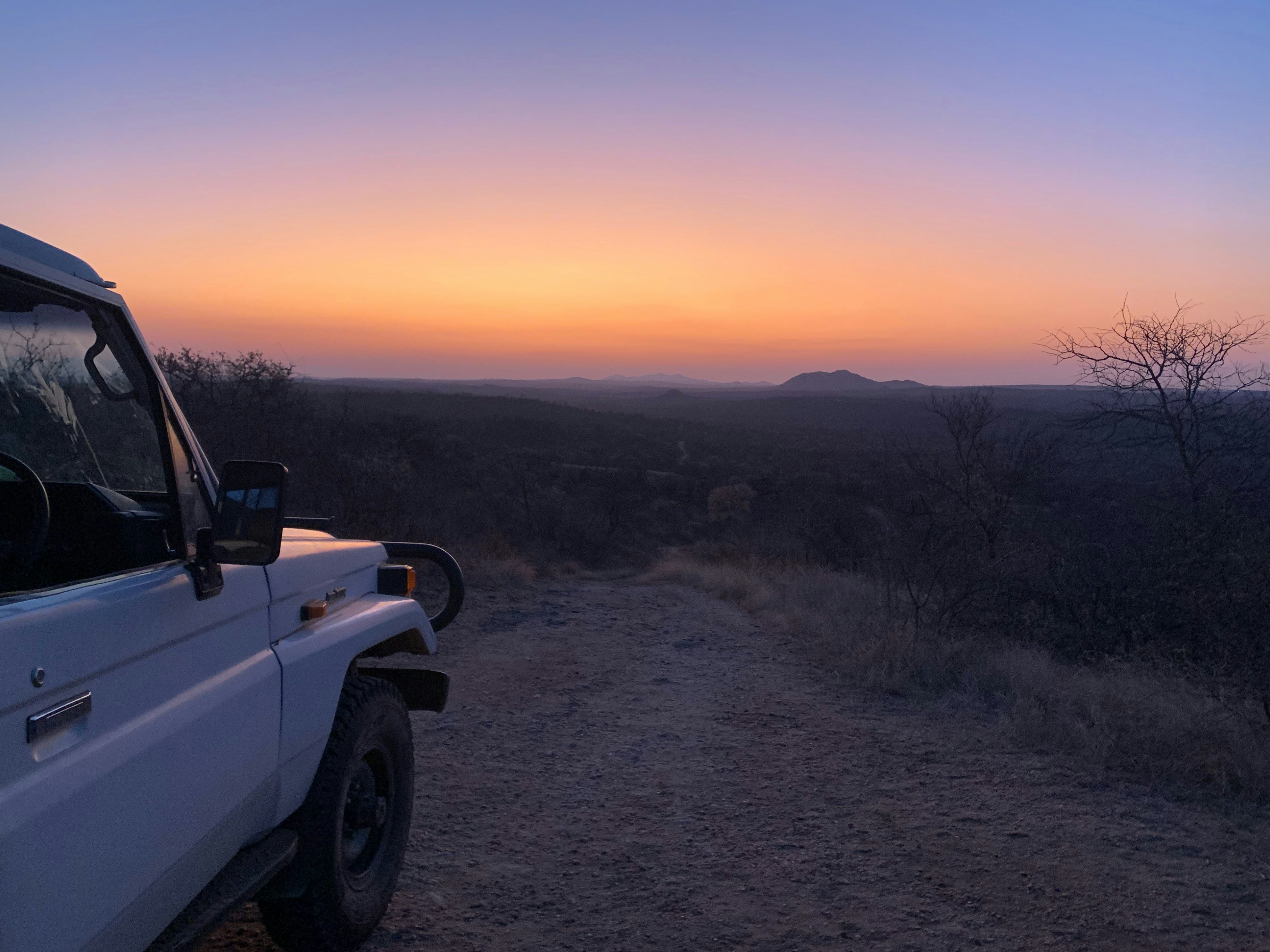 a car parked on a dirt road, Bushveld Sunset in Balule