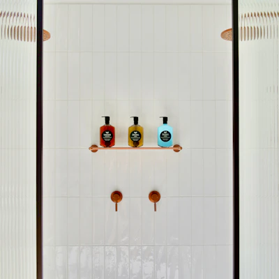 A minimalist suction shower hook firmly attached to a tiled bathroom wall.