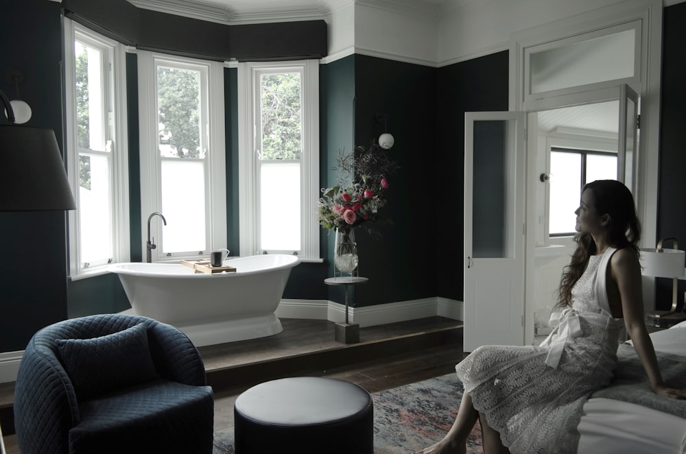 a woman sitting on a chair in a bathroom