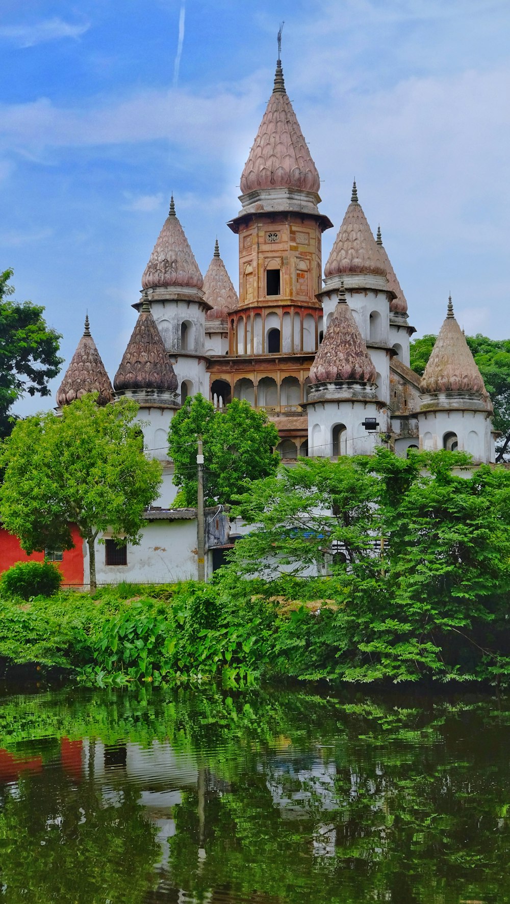 a castle with pointy roofs by a body of water