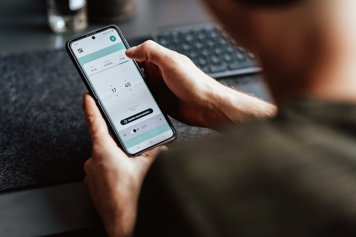 A close-up of a person scheduling tasks on a mobile device.