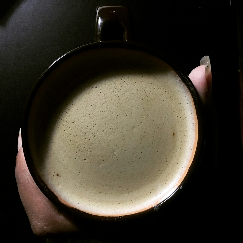 a hand holding a cup of coffee