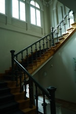 A beautifully crafted wooden staircase with elegant railings in a bright, airy interior space.