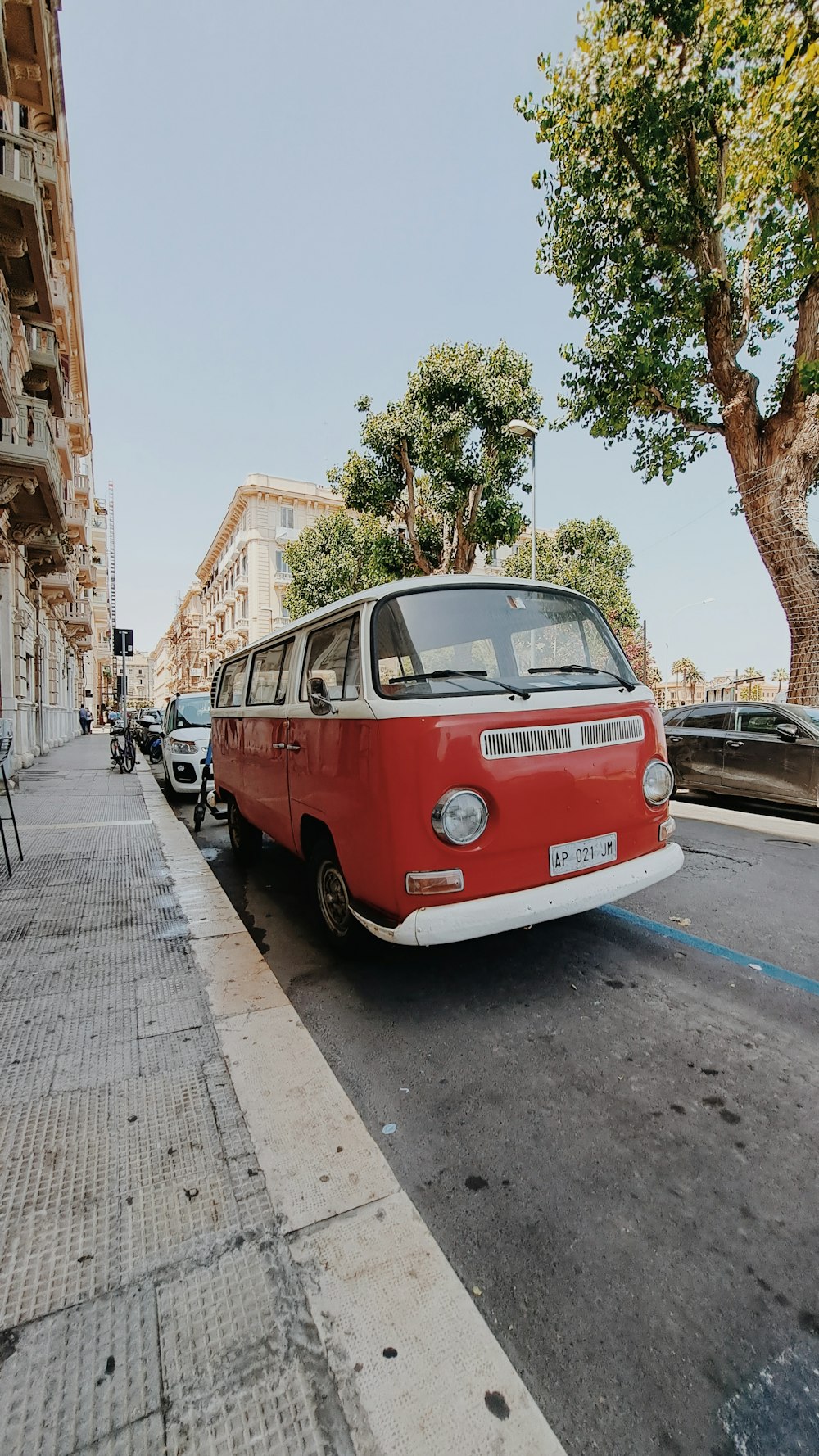 Una furgoneta roja estacionada al costado de una calle