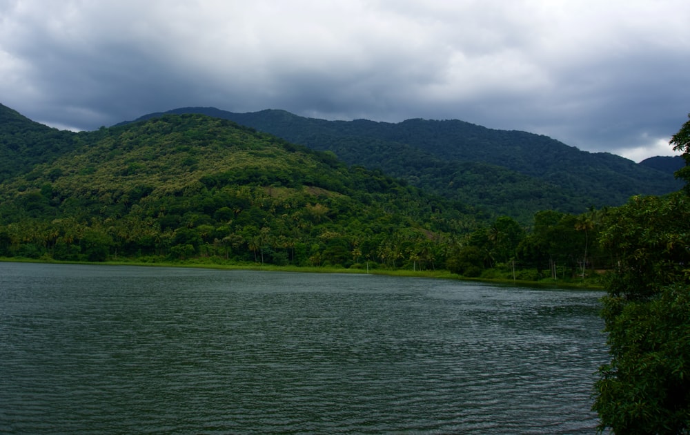 a body of water with trees and hills in the background