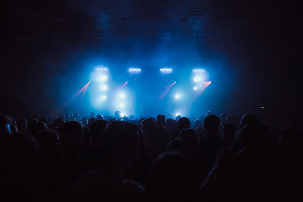 a crowd of people watching a stage with lights