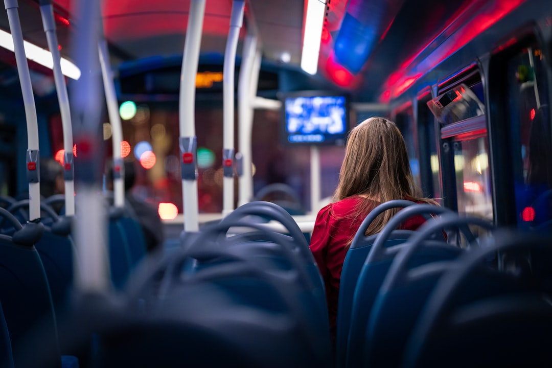 a person sitting on a bus, A person sitting alone in a bus in London.