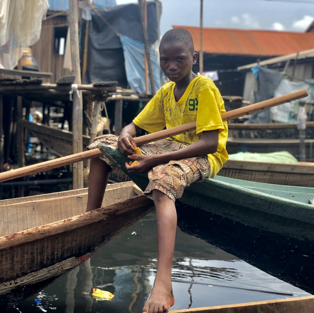 a boy sitting on a boat