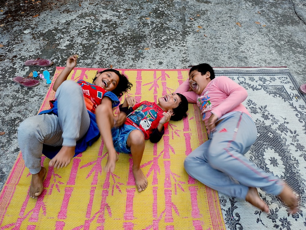 a group of people lying on a colorful rug