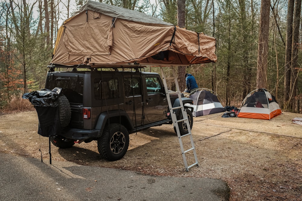 a van with a tent and a ladder in front of it