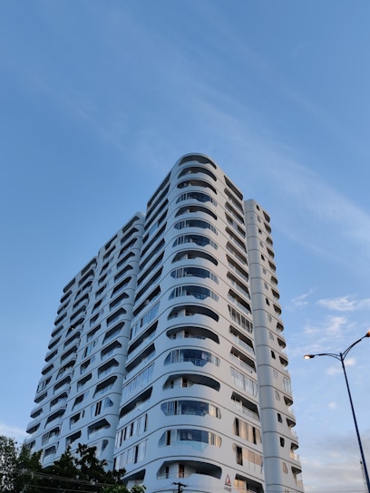 A sleek modern residential building with clean lines and golden accents under a clear blue sky.