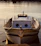 Elegant floating luxury boat docked at sunset with warm wooden textures and soft blue water reflections.