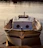 Elegant floating luxury boat docked at sunset with warm wooden textures and soft blue water reflections.