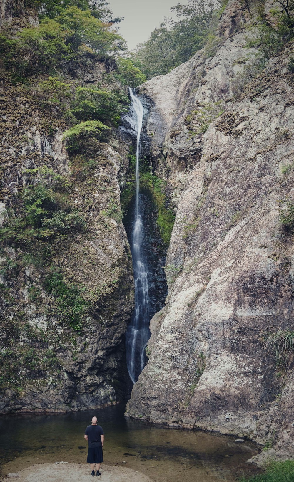 a person standing next to a waterfall