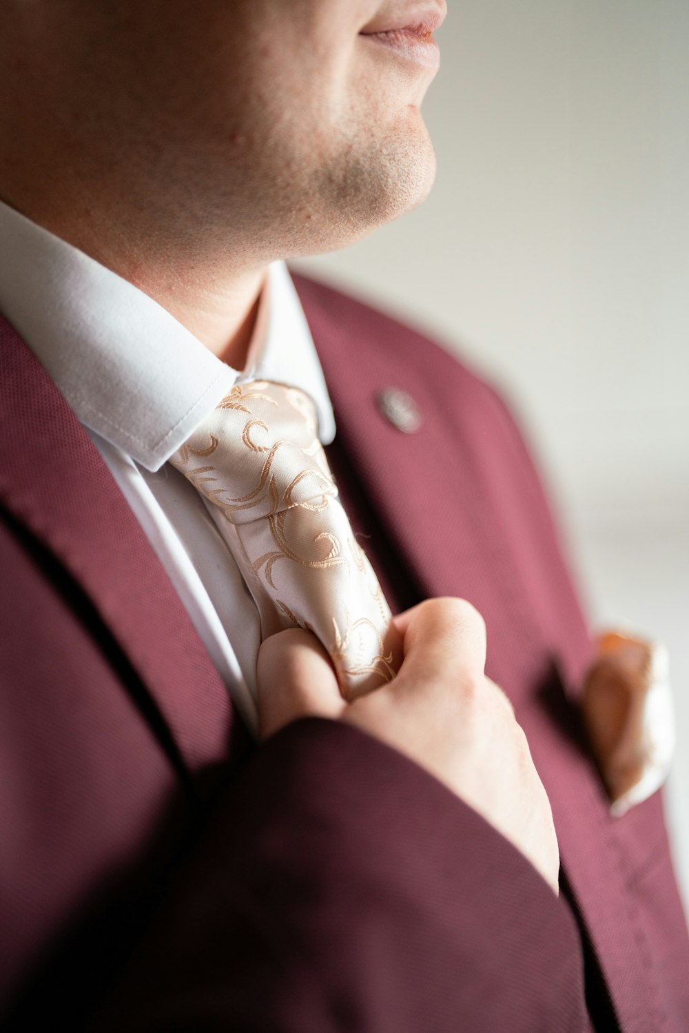 a man in a pink shirt and tie holding a pink bow tie