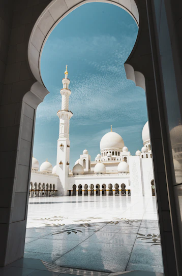 A serene view of Noorani mosque's elegant dome and minaret against a clear blue sky.