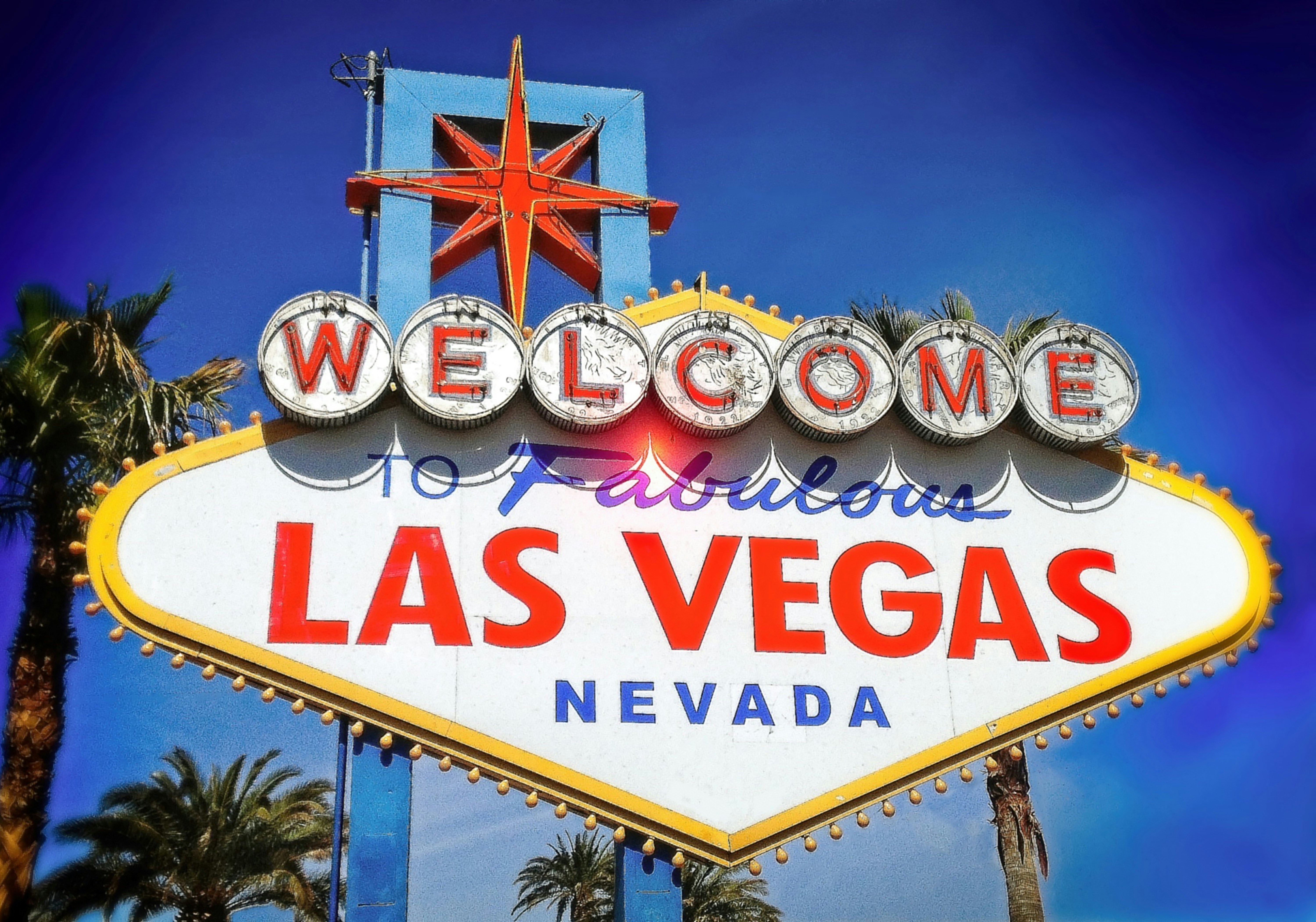a sign with a star on top with Welcome to Fabulous Las Vegas sign in the background