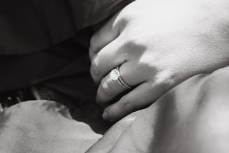 An intimate close-up of a wedding ring resting on a soft fabric.