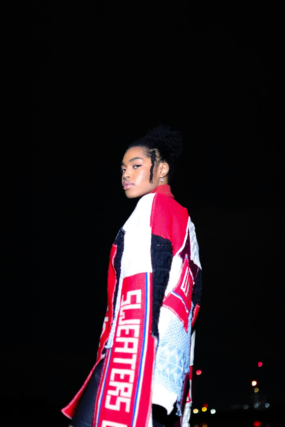 a man in a red and white striped shirt with a white and black scarf around his neck