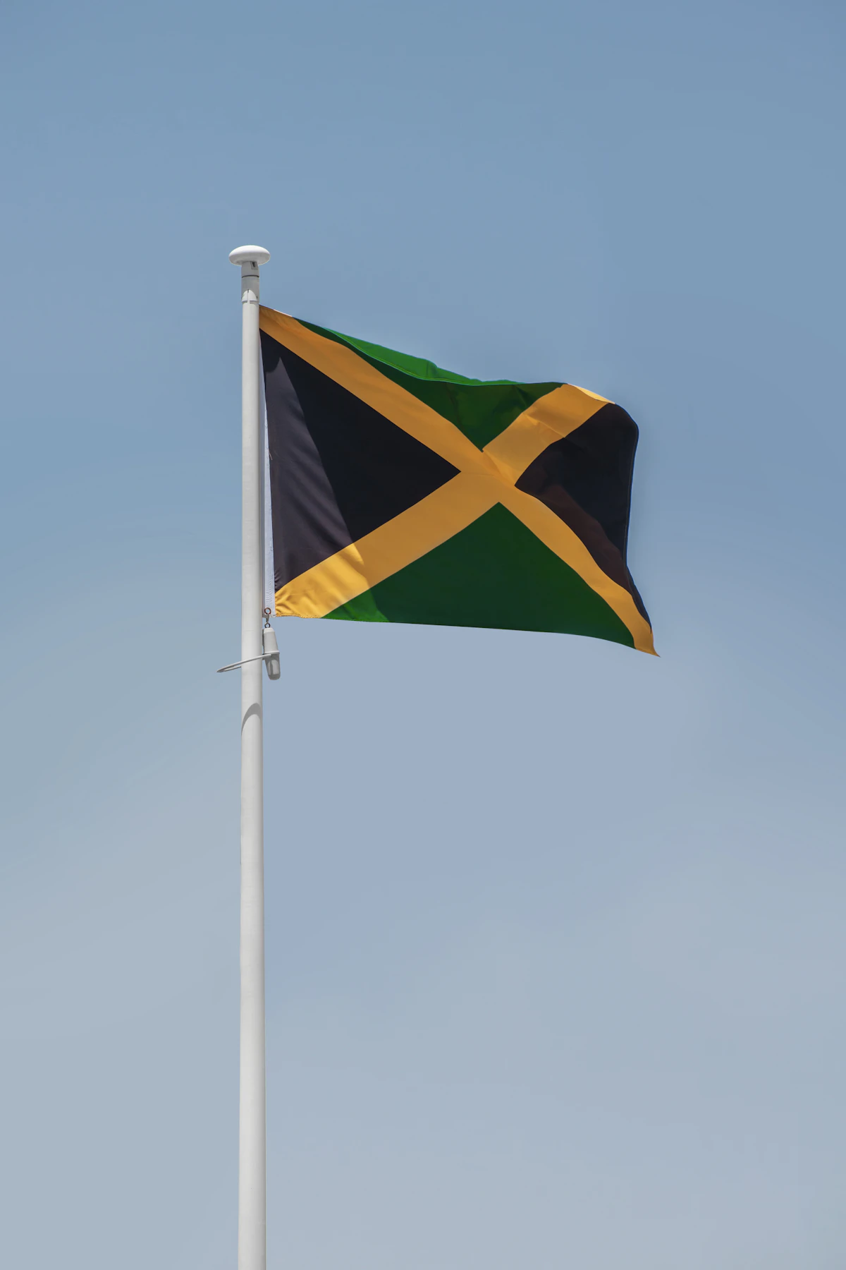 The flag of Jamaica against a clear sky, representing the country hosting the Commonwealth Parliamentary Association's Caribbean regional conference on AI and disinformation