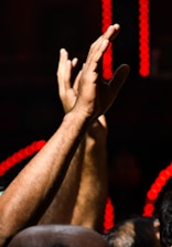 Close-up of hands clapping in rhythm at a lively dance show.
