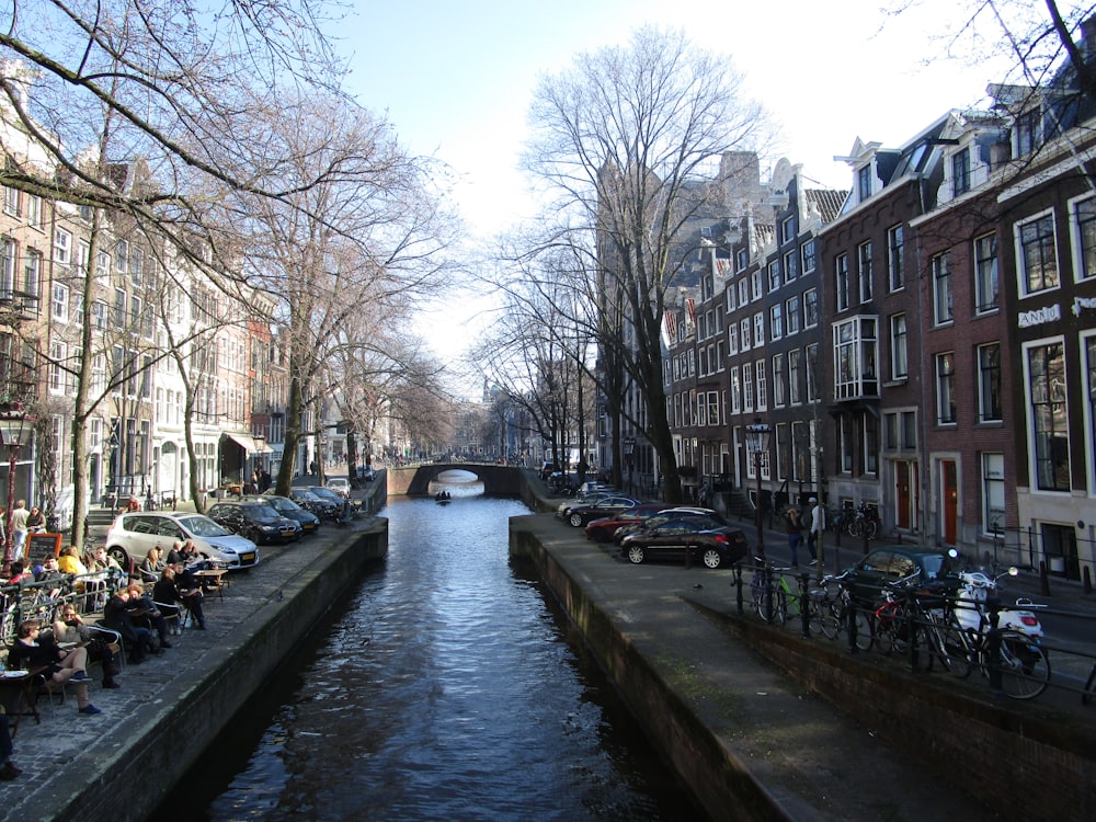 a canal with a row of buildings and bicycles parked on the side