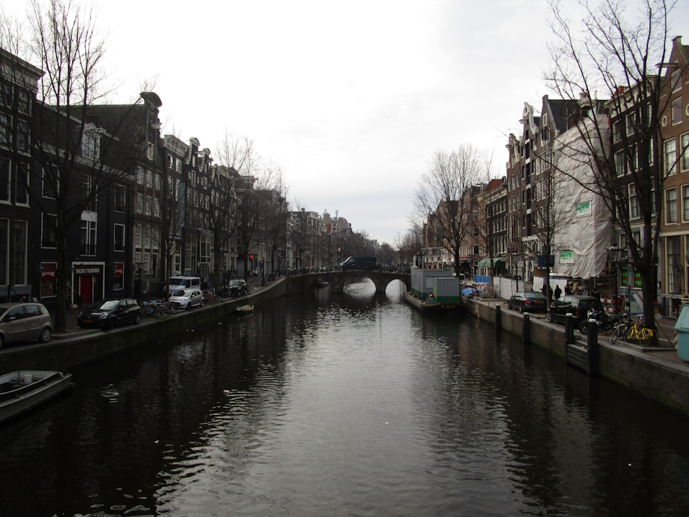 a canal with a boat in it and buildings on the side with Canal Saint-Martin in the background