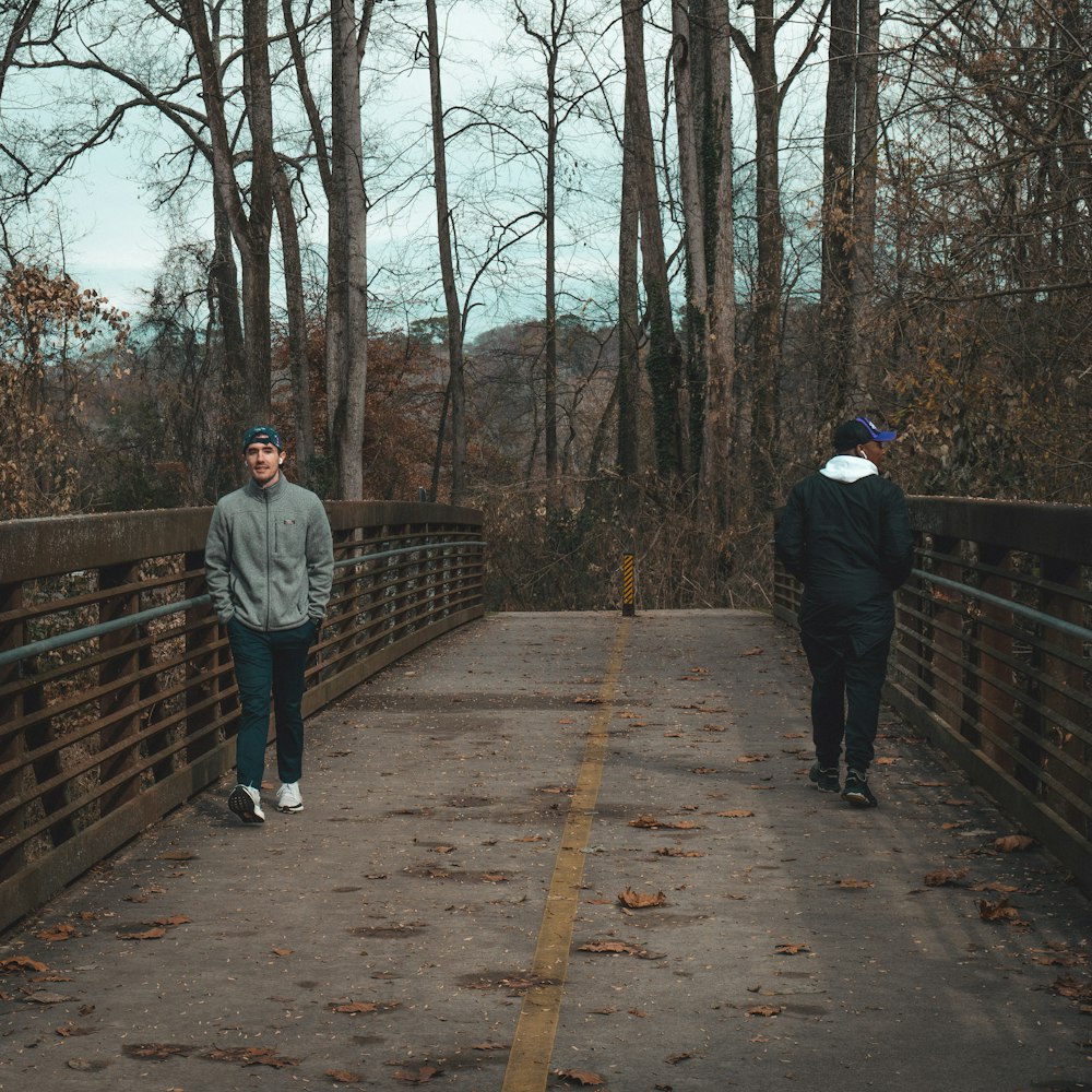 two men standing on a bridge