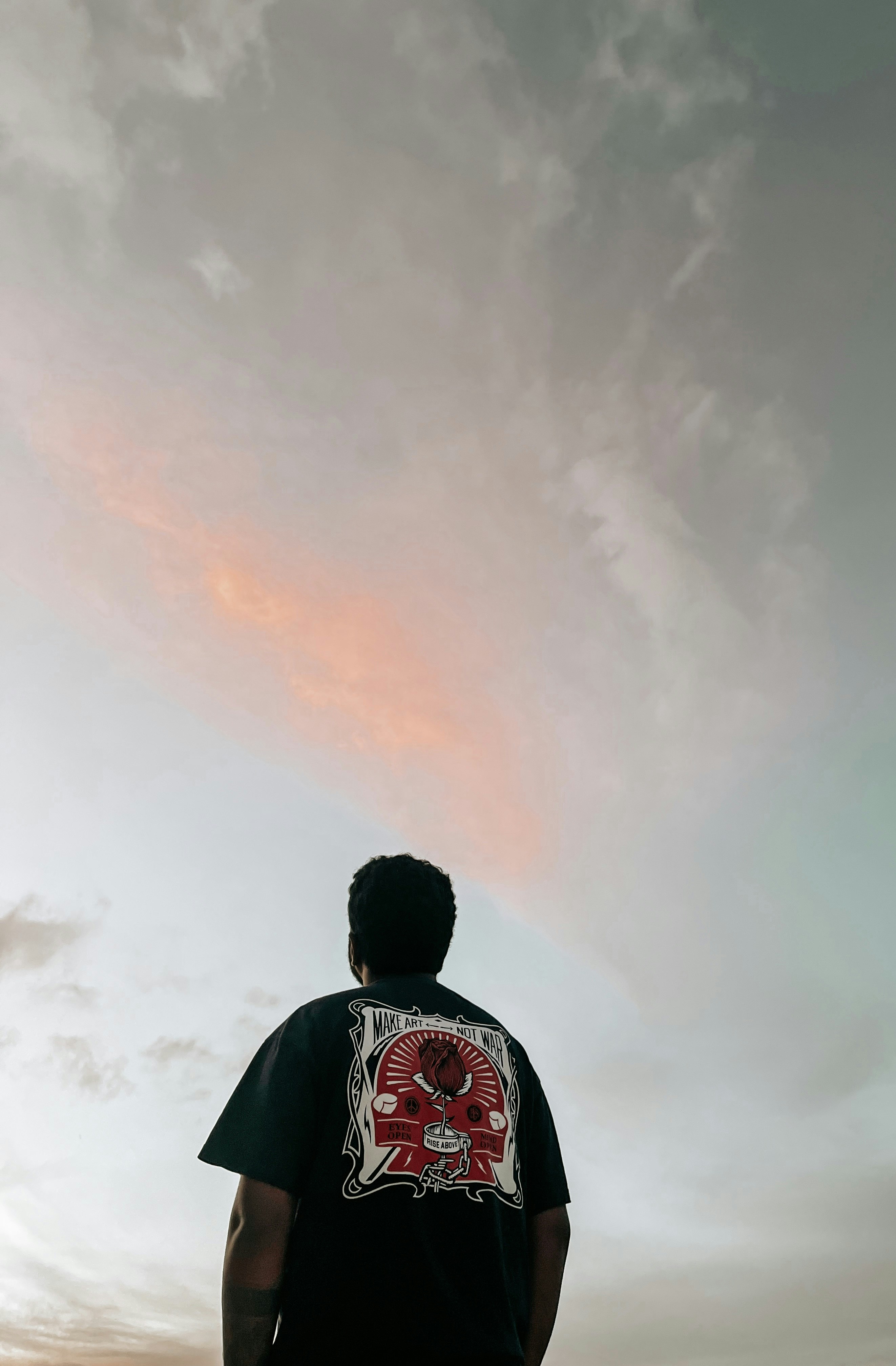 Oversized black t-shirt with graphic print, worn casually, dark moody background