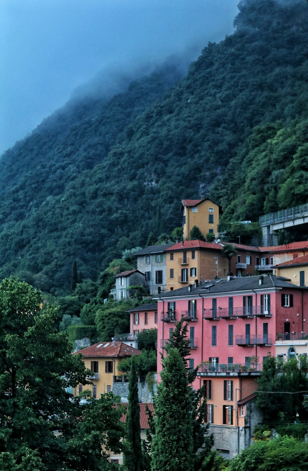 a group of buildings in front of a mountain