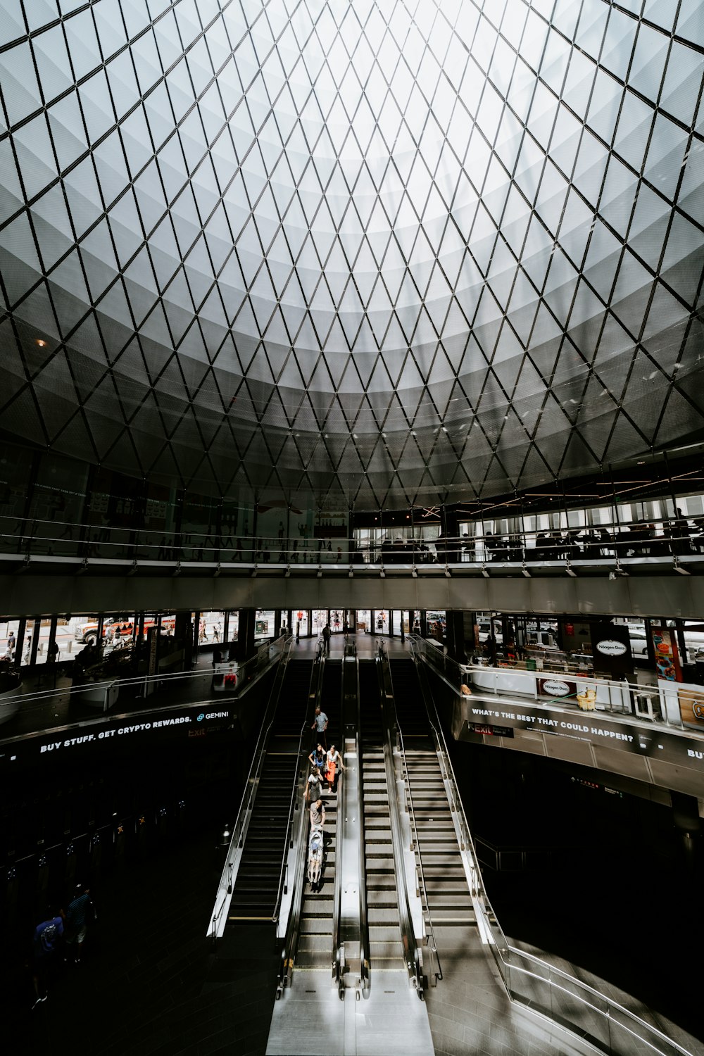 a large glass dome with a walkway and people walking on it